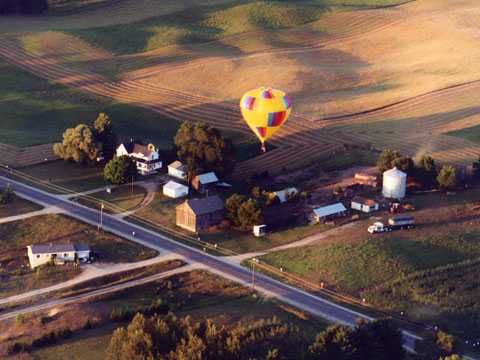 Both balloons from nearby roads, positioning vehicles in the open field for recovery.